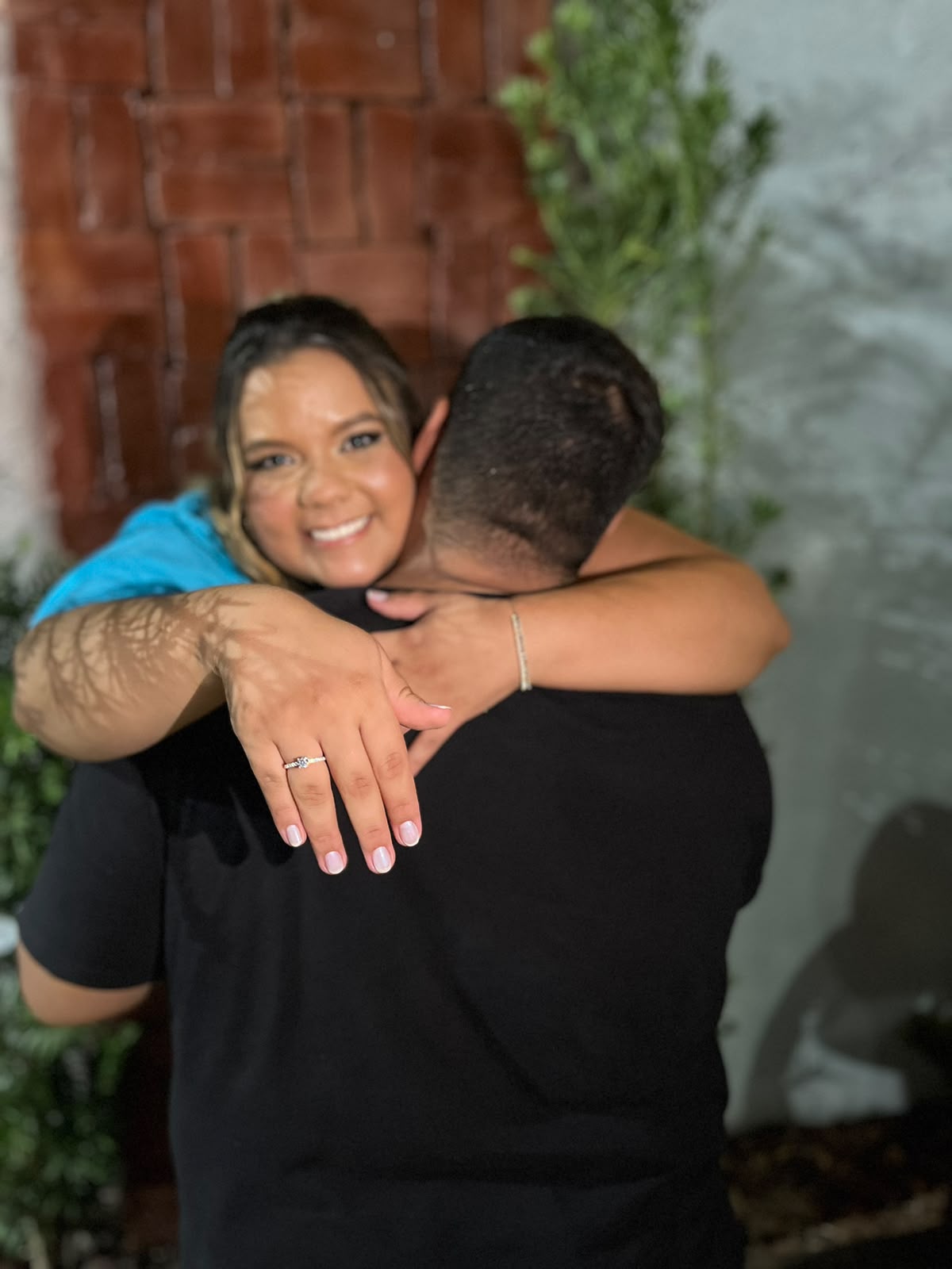 Thayssa e Gabriel abraçados, com a aliança de noivado em destaque