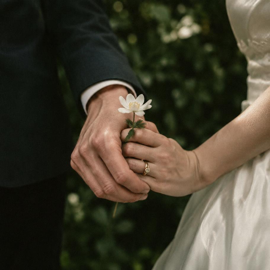 Imagem ilustrativa: mãos de um casal segurando uma flor